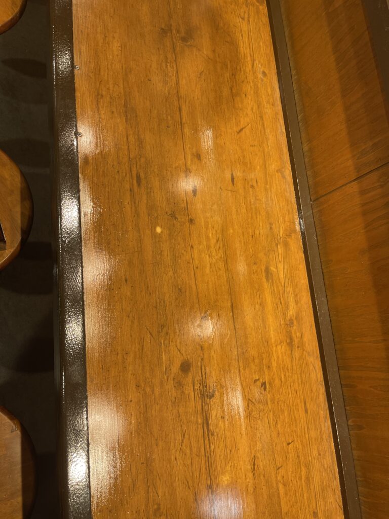 店舗の木製テーブル塗装工事の施工後、ツヤのある美しい仕上がり
