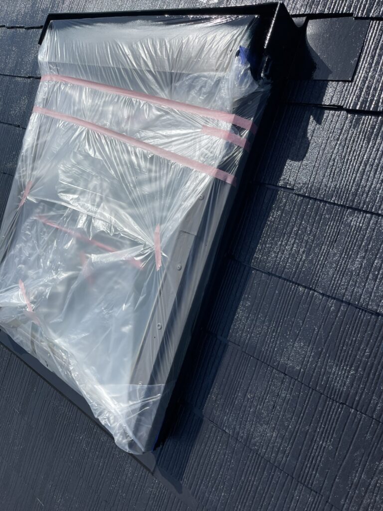 写真は「屋根の天窓部分をビニール養生して塗装準備をしている様子」です。